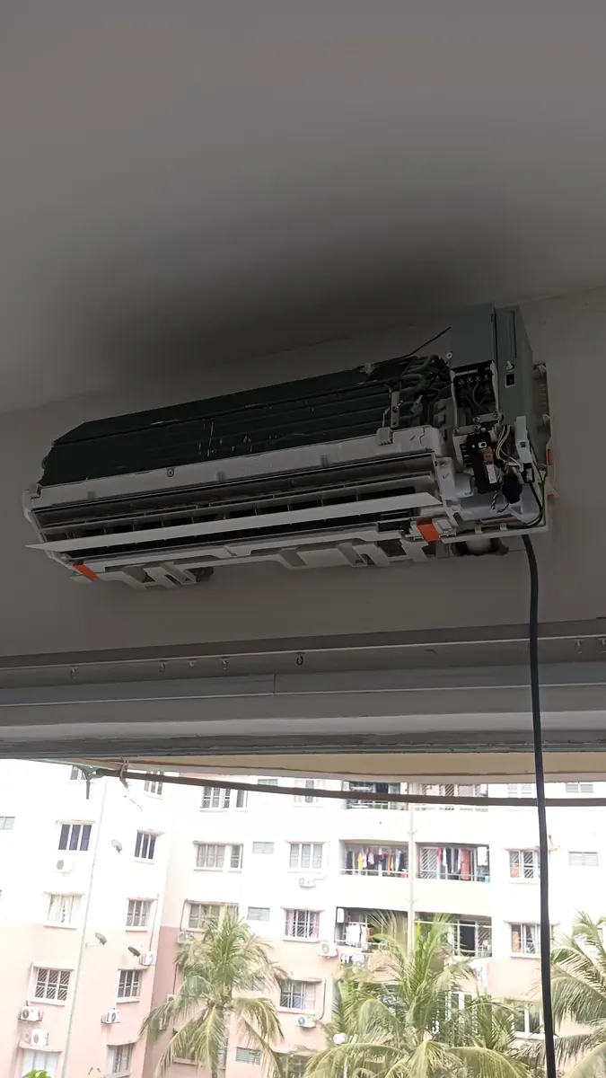 Wall-mounted aircond indoor unit opened up for servicing, exposing the evaporator coil and blower that both Dry mode and Cool mode depend on, in a Kuala Lumpur condominium