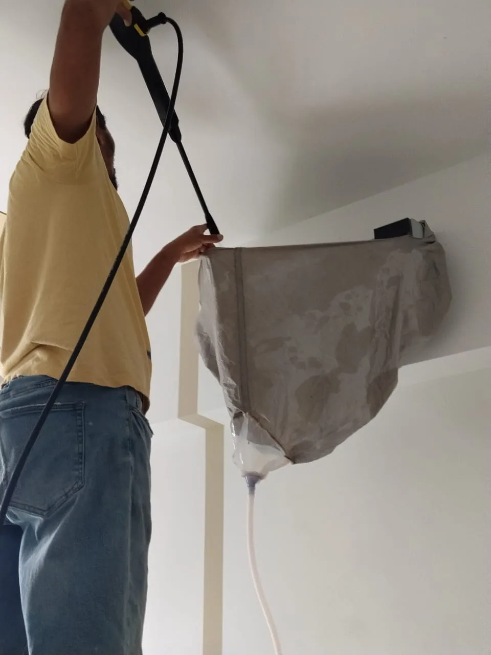 KL Renovator technician performing a full chemical overhaul with the unit dismantled on an aircond unit in aircond chemical wash