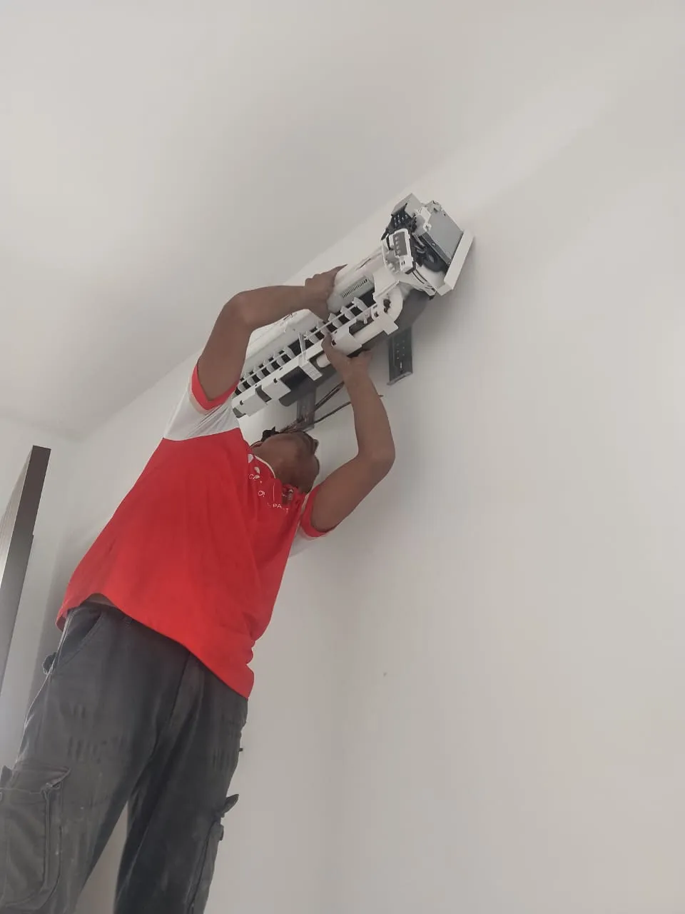 Wall-mounted aircond receiving basic servicing and filter cleaning in a Puchong home