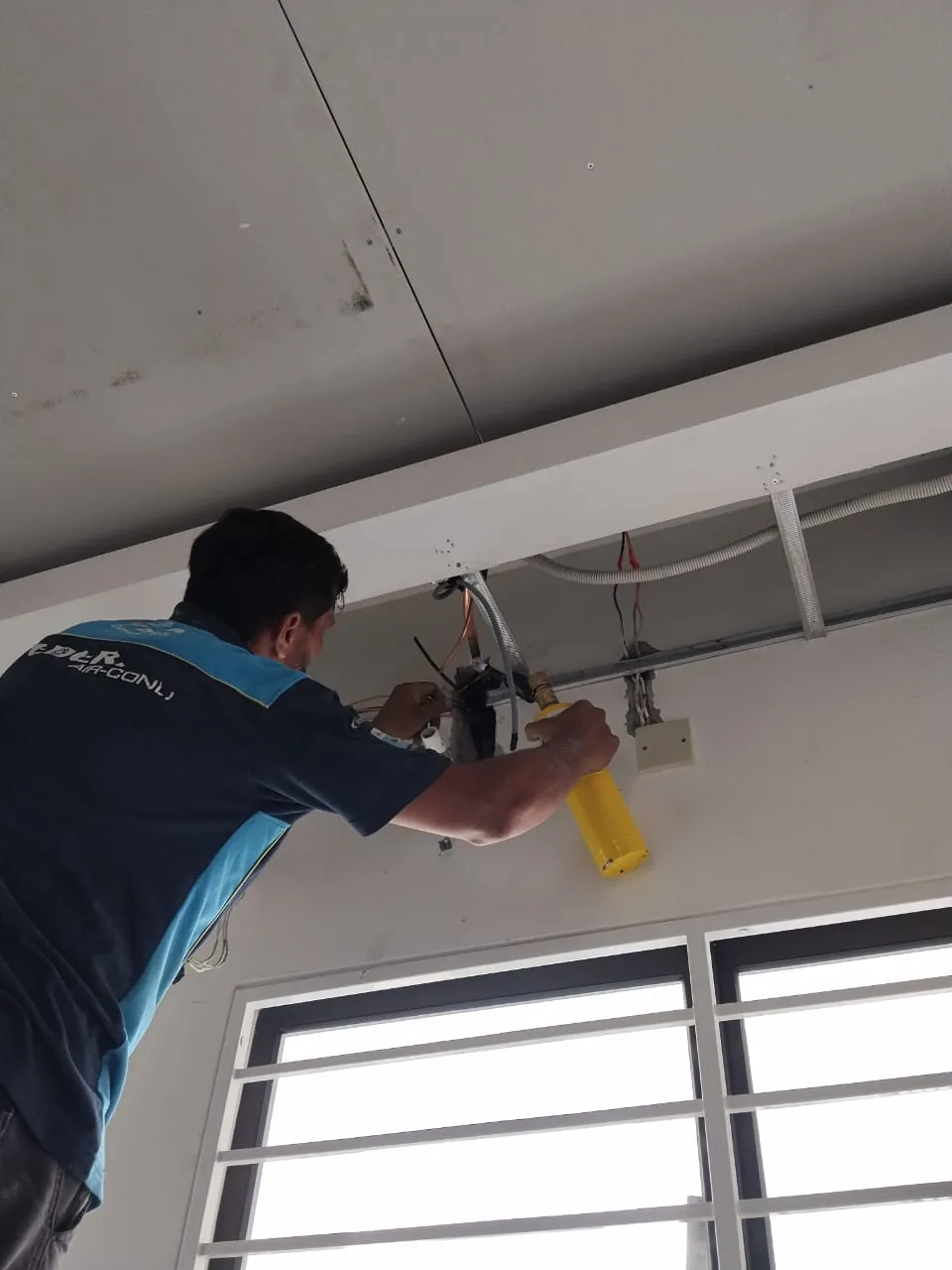 KL Renovator technician performing outdoor compressor repair and replacement on a National unit across KL & Selangor