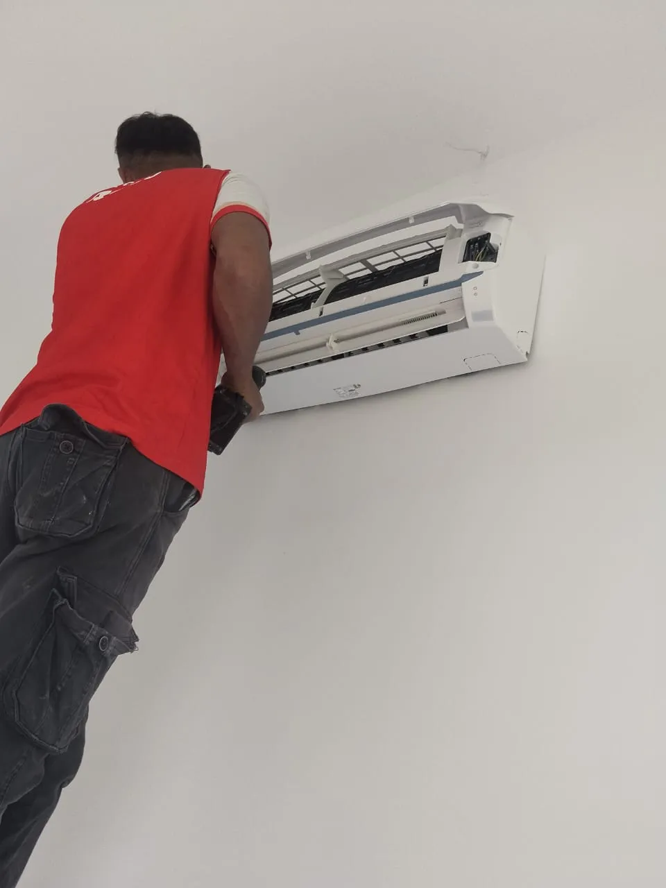 Vacuum pump and manifold gauges connected for commissioning after a wall-mounted aircond installation in Kuala Lumpur